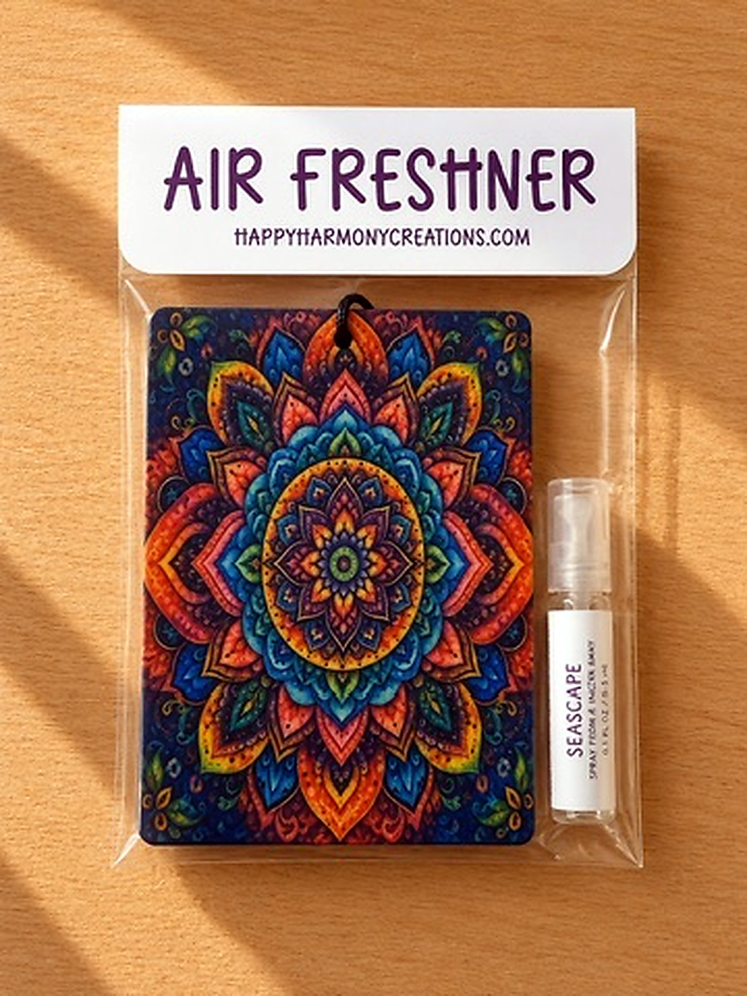 packaged rectangular air freshener with colorful mandala artwork and scent bottle