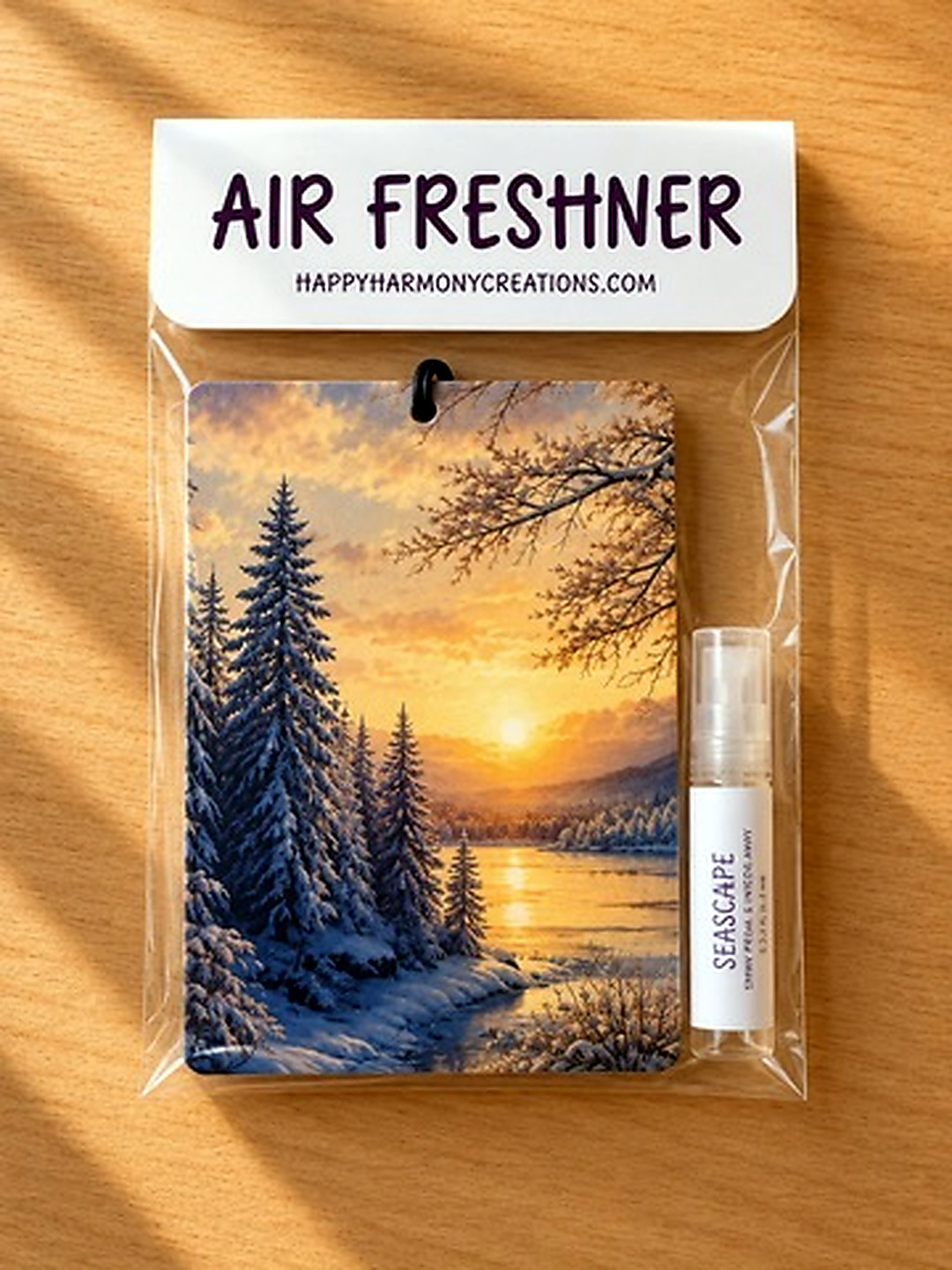 packaged rectangular air freshener with mountain sunrise artwork and scent bottle
